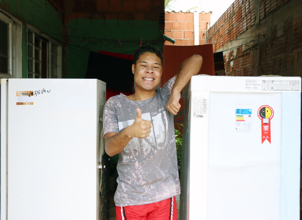 Vinícius Santos comemora o refrigerador novo e eficiente.