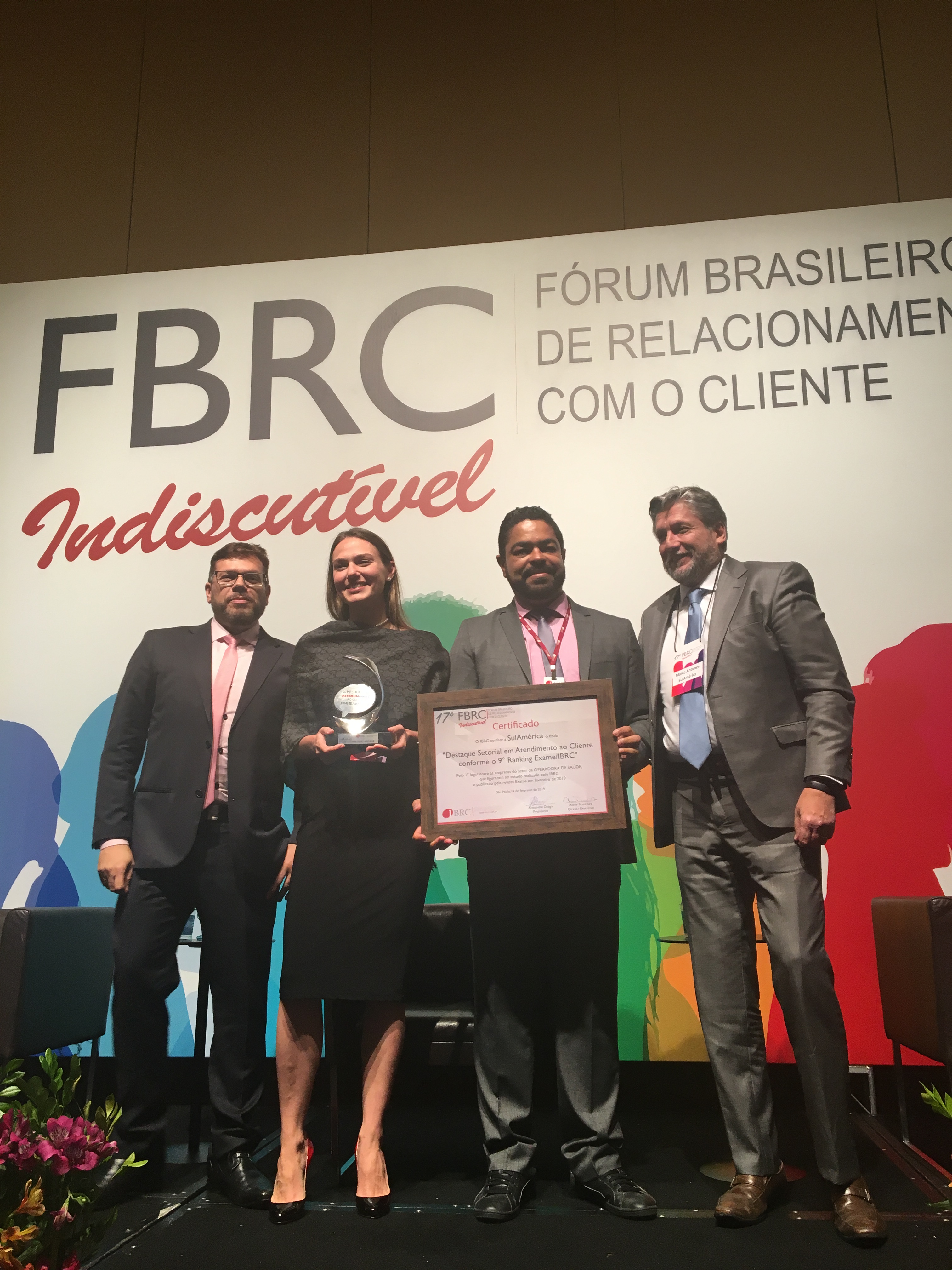 Marco Antunes (4º da esq. para a dir.) e Raquel Giglio, da SulAmérica, recebem prêmio  durante o Fórum Brasileiro de Relacionamento com o Cliente